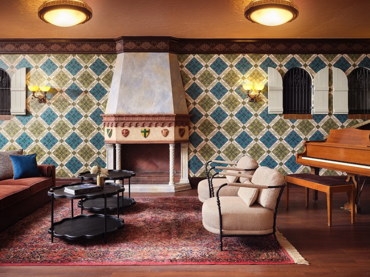 Luxurious living room with a grand fireplace, patterned tile walls, comfy seating, a grand piano, and warm ambient lighting for a cozy, elegant vibe.